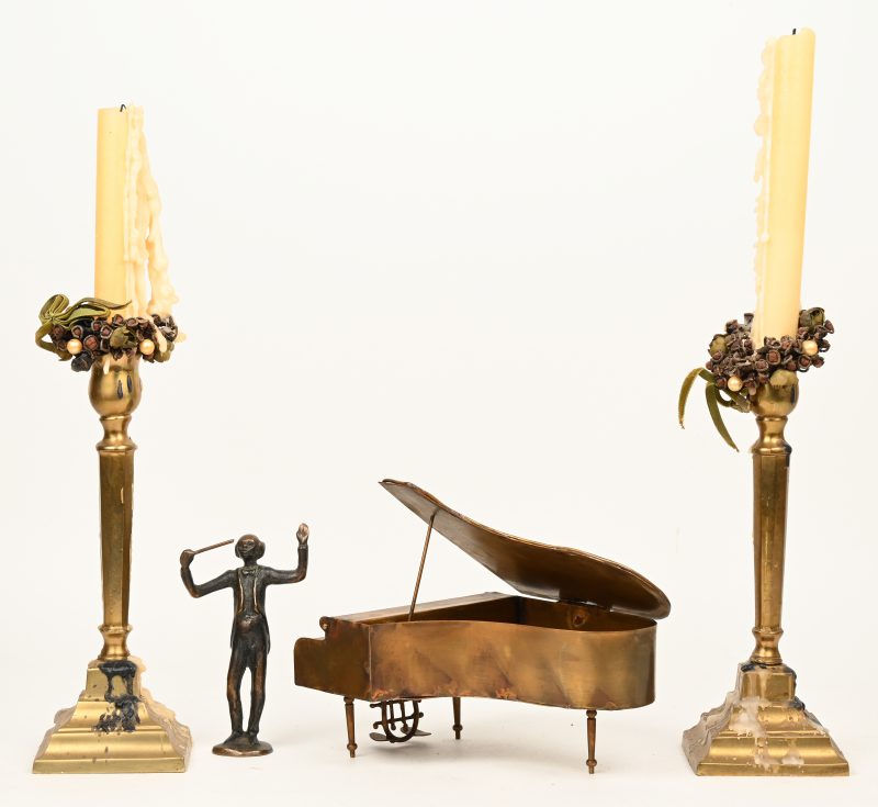 Een paar messingen kandelaars, een geelkoperen miniatuur piano gesigneerd D’haeseleer en een bronzen beeldje van een dirigent.