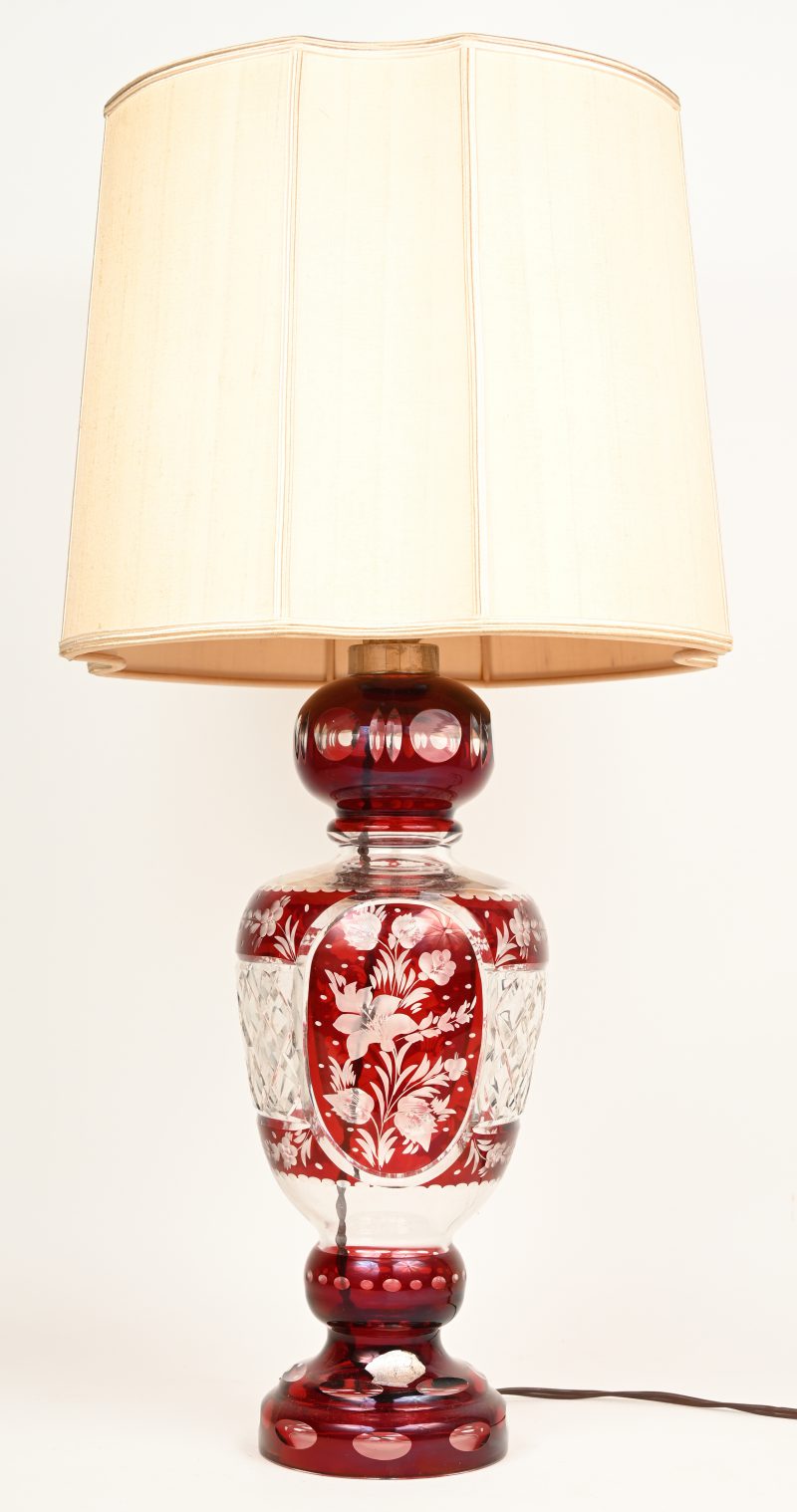 Een lampvoet van kleurloos en rood kristal met een lampenkap. Gemerkt.