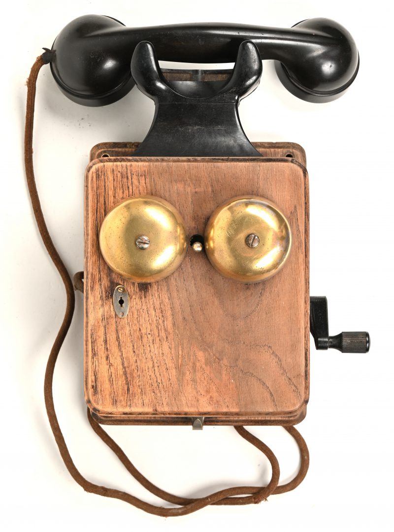 Een oude houten wandtelefoon.