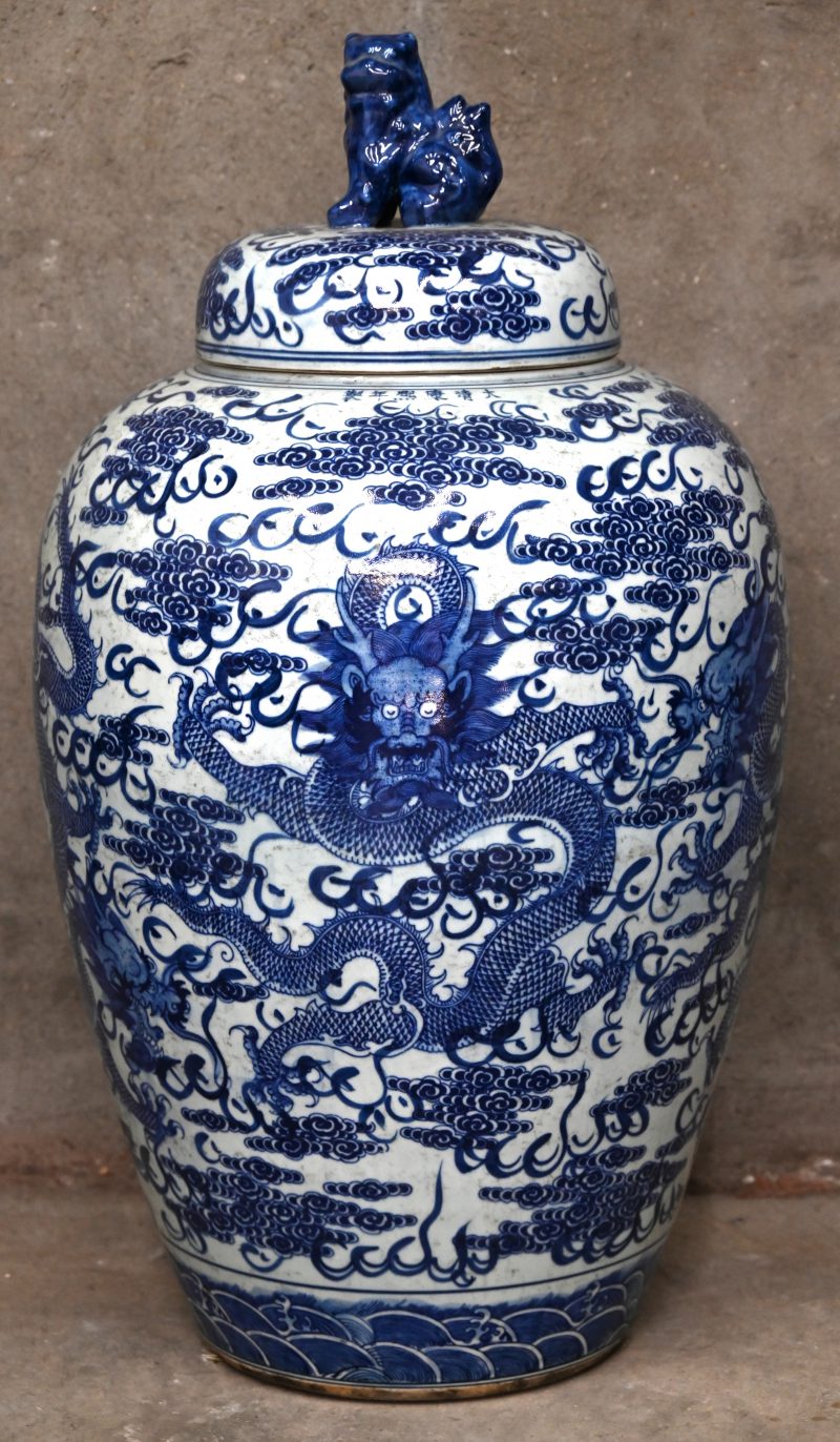 Een grote dekselvaas van Chinees wit en blauw porselein. Versierd met draken in het decor en een tempelleeuw op het deksel.