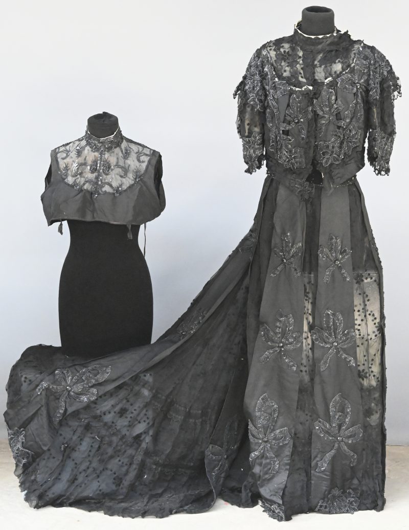 Een rok en bijpassende bolero van zwart satijn met borststukje versierd met kant en pailletten in bloemvorm.