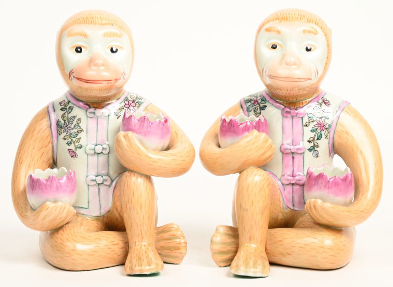 Een paar porseleinen aapjes met telkens twee kaarsenhouder. Chinees werk.