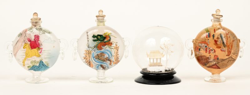 Een lot bestaande uit drie glazen chinese snuff bottles met diverse decors en een kleine globe van plastiek met een pagode.