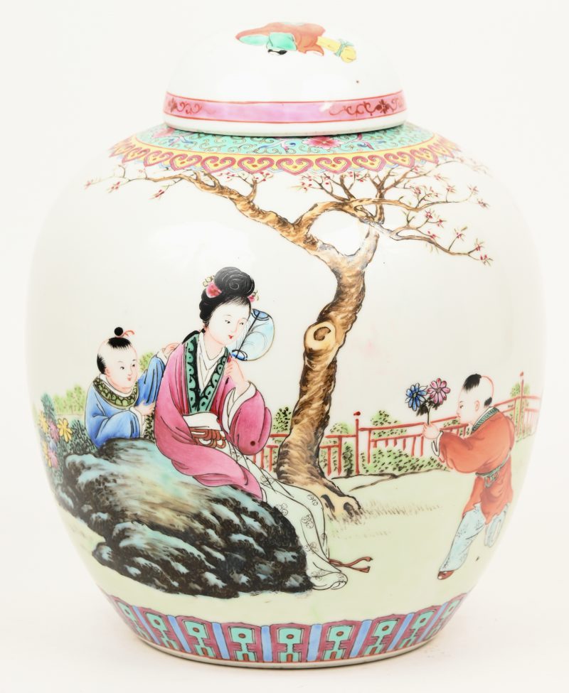 Een dekselpot van meerkleurig chinees porselein met personage bij een boom in het decor. Onderaan gemerkt.