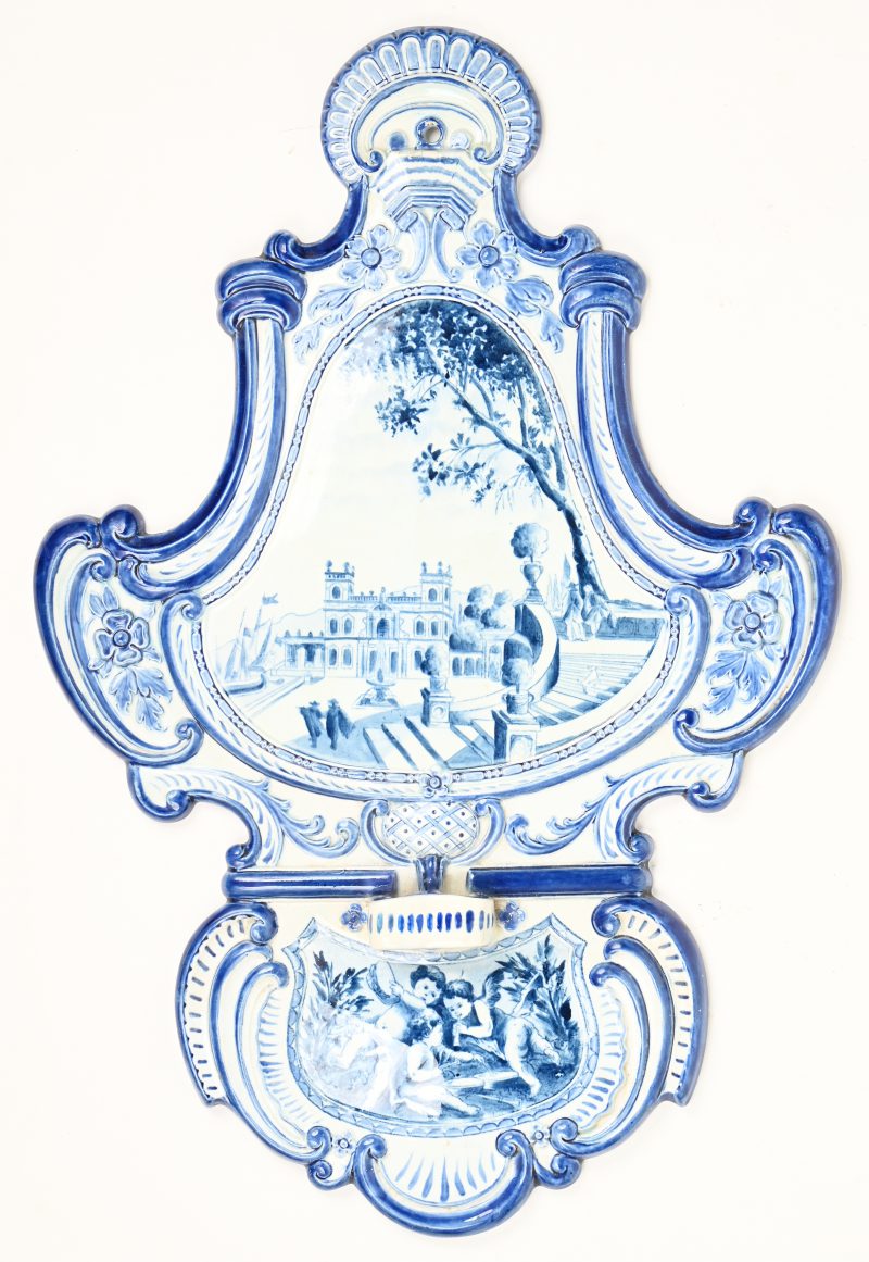 Een pijpenhouder van blauw en wit porselein met een landhuis en engelen in het decor. Achteraan genummerd en gemerkt.
