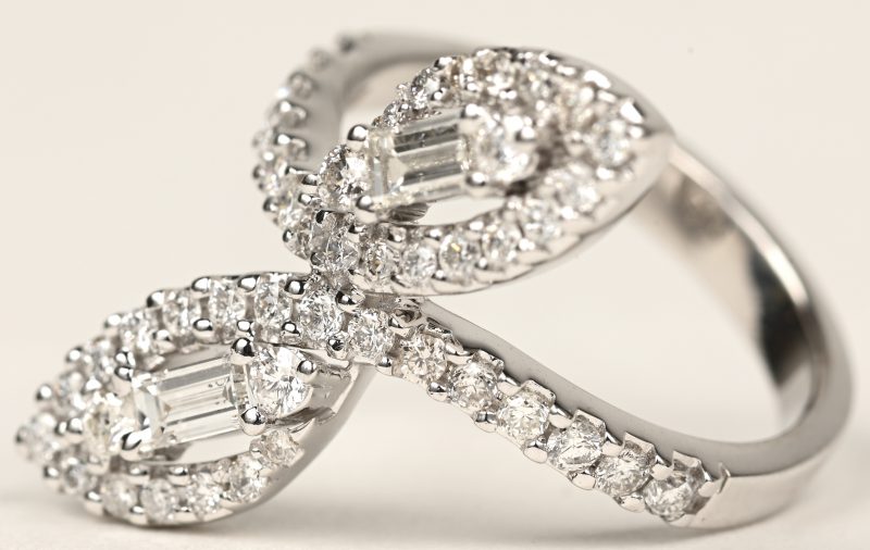 Een 18 K witgouden ring bezet met briljanten en diamant baguetten met een gezamenlijk gewicht van +- 1,12 ct.