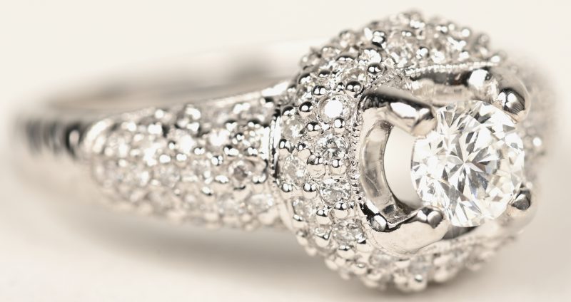 Een 18 K witgouden ring bezet met briljanten met een gezamenlijk gewicht van +- 0,57 ct. en centrale diamant van +- 0,44 ct.