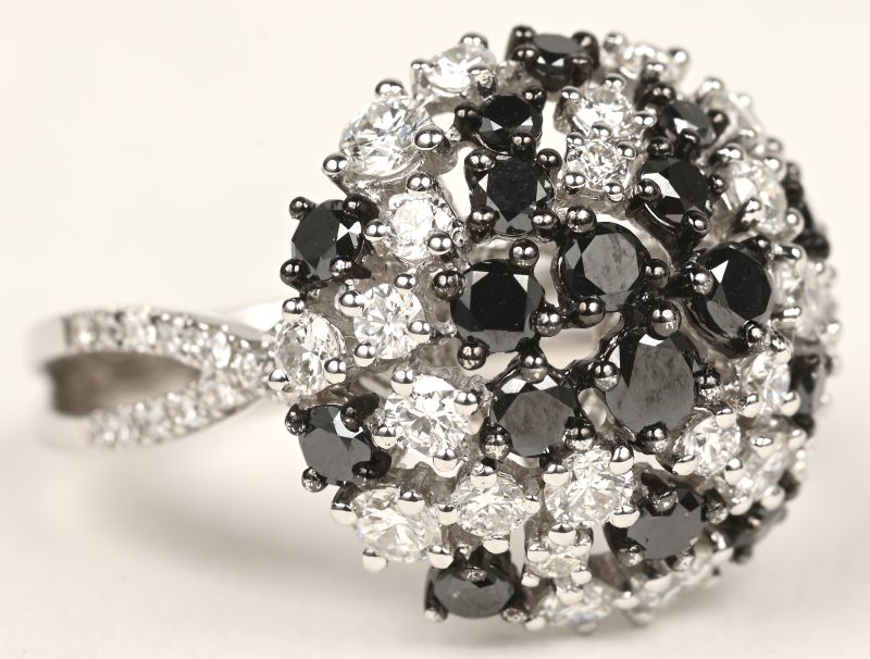 Een 18 K witgouden ring bezet met briljanten en zwarte diamanten met een gezamenlijk gewicht van +- 2,10 ct.