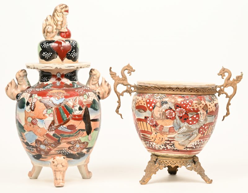 Twee stuks Japans aardewerk, bestaande uit een dekselvaas en een jardinière messingen pootjes en draakvormige handvatten.
