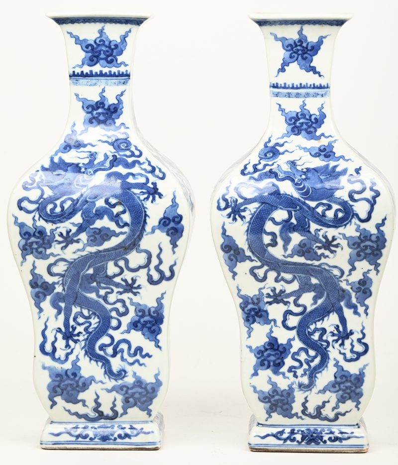 Een paar vazen van Chinees porselein met een blauw op wit decor van draken en goudfazanten. Onderaan gemerkt.