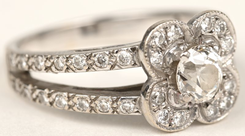 Een 18 K witgouden bloemvormige ring bezet met diamanten met een gezamenlijk gewicht van 0,80 ct.