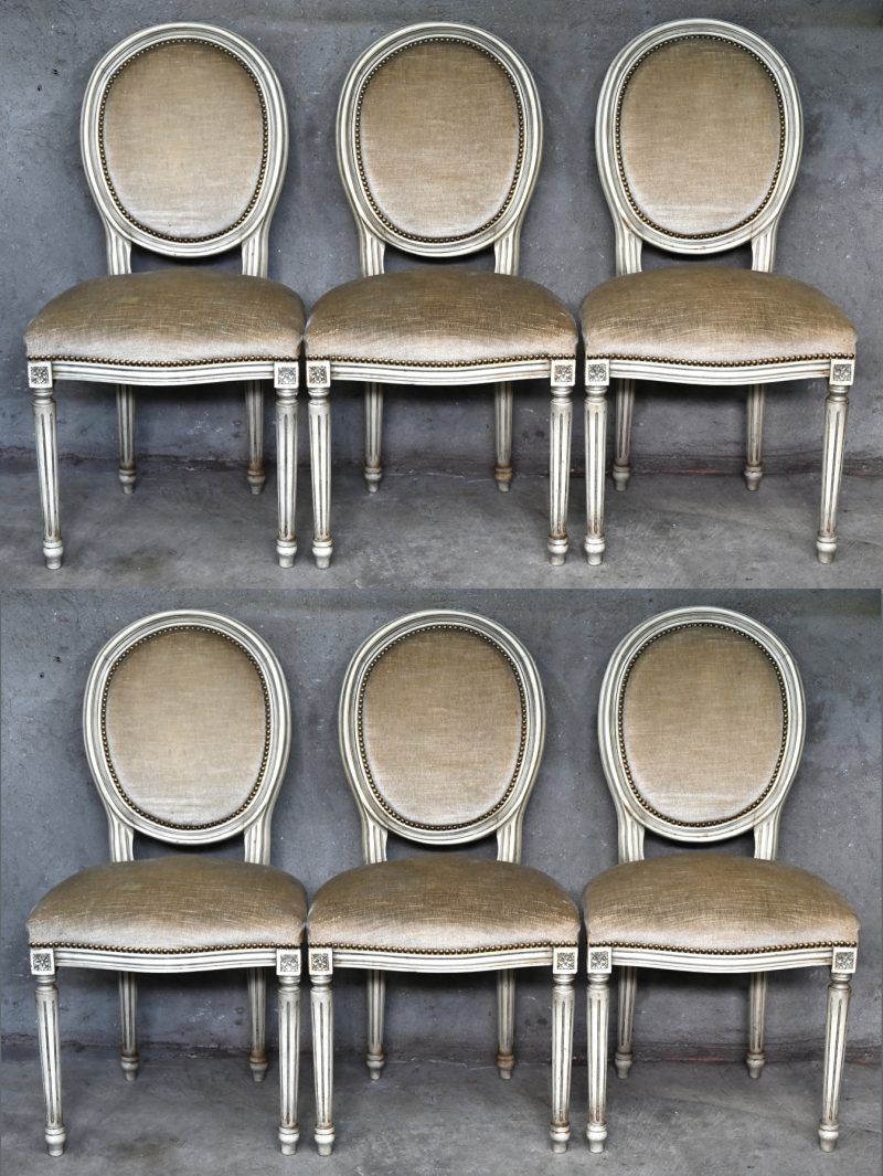 Een reeks van zes beigegepatineerde stoelen in Lodewijk XVI-stijl, bekleed met fluweel.