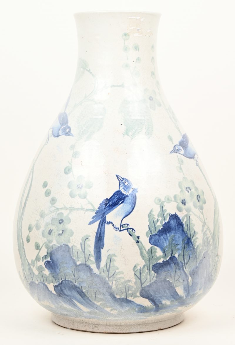 Een vaas van chinees porseleinen met een blauw en wit decor met vogels en planten. Onderaan schade.