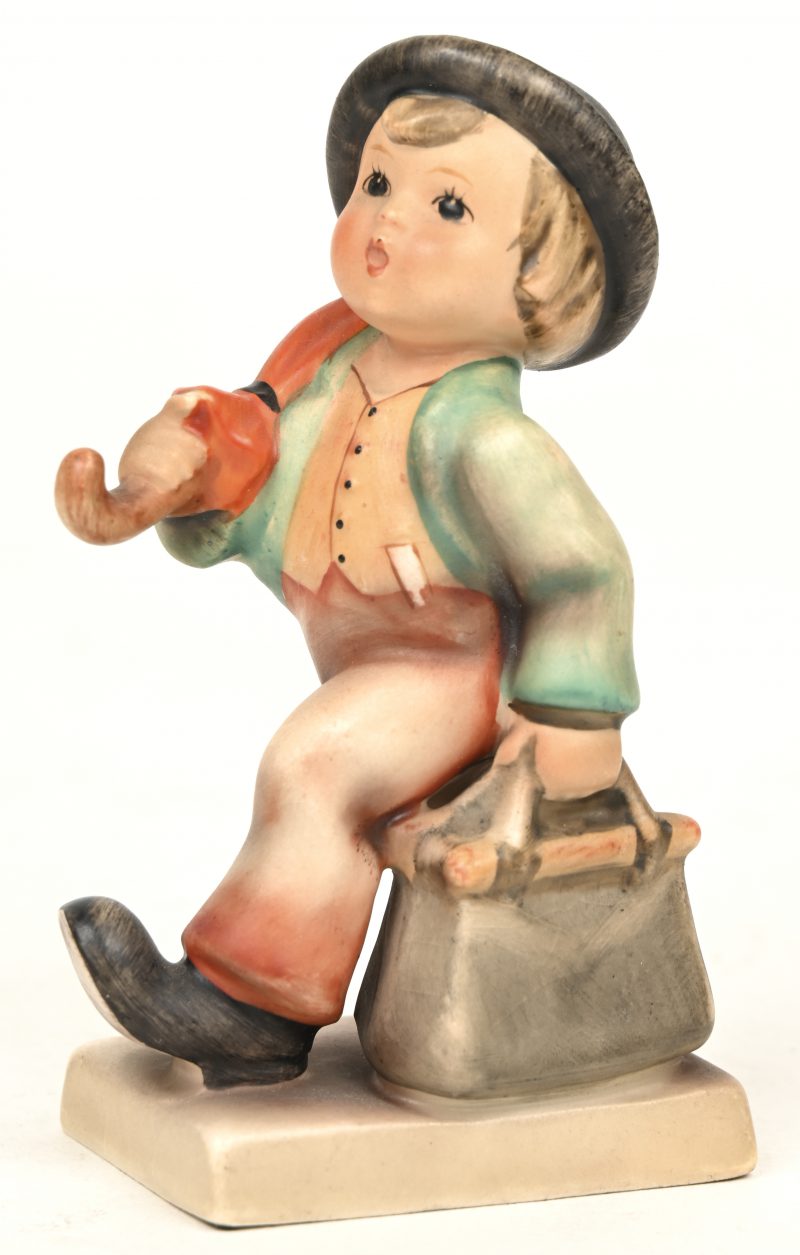 “Wanderbub”. Een beeldje van meerkleurig bicuit uit de reeks van M.I. Hummel. No. 11 2/0. Onderaan gemerkt.