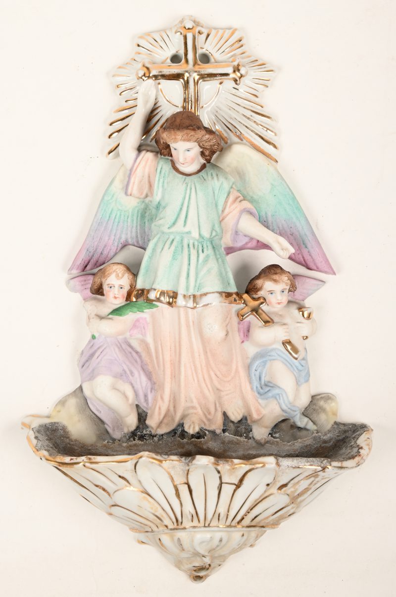 Een wijwatervaatje van meerkleurig porselein versierd met drie engelen.