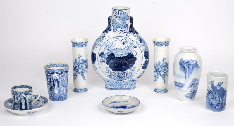 Een lot blauw en wit Chinees porselein, bestaande uit een paar lange vaasjes, een klein vaasje, een penseelkokertje, een flesvaas, een kopje op schotel en een bekertje op schotel.