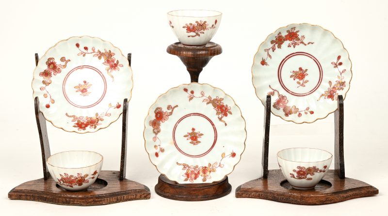 Drie kleine theekopjes en schoteltjes van Chinees porselein met een guirlandedecor in rood, rose en goud naar Imari-voorbeeld. Geribde vorm. XIXde eeuw.