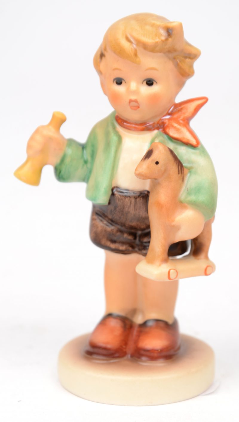 “Junge mit Holzpferd”. Een beeldje van meerkleurig biscuit uit de reeks van M.I. Hummel. Onderaan gemerkt. No 239/c.