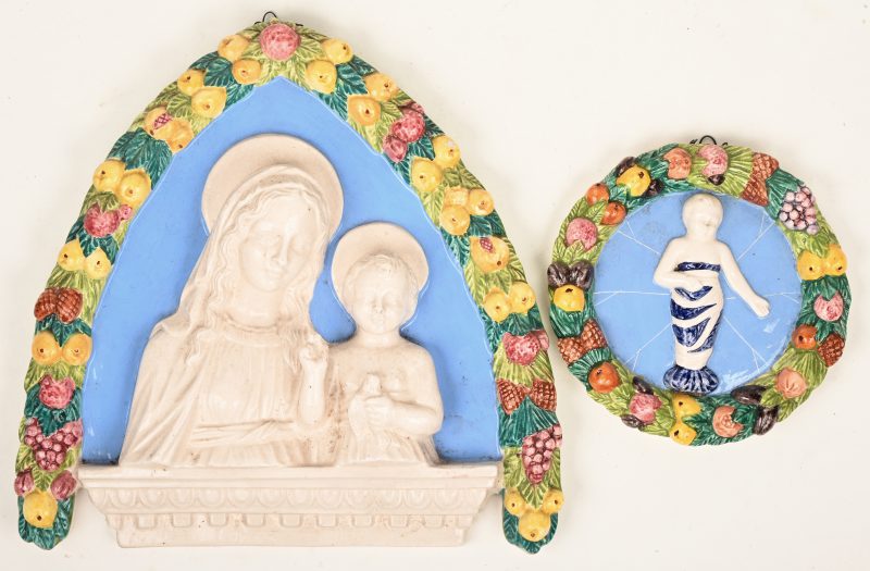 Twee meerkleurig aardewerken wanplaquettes in reliëf.
