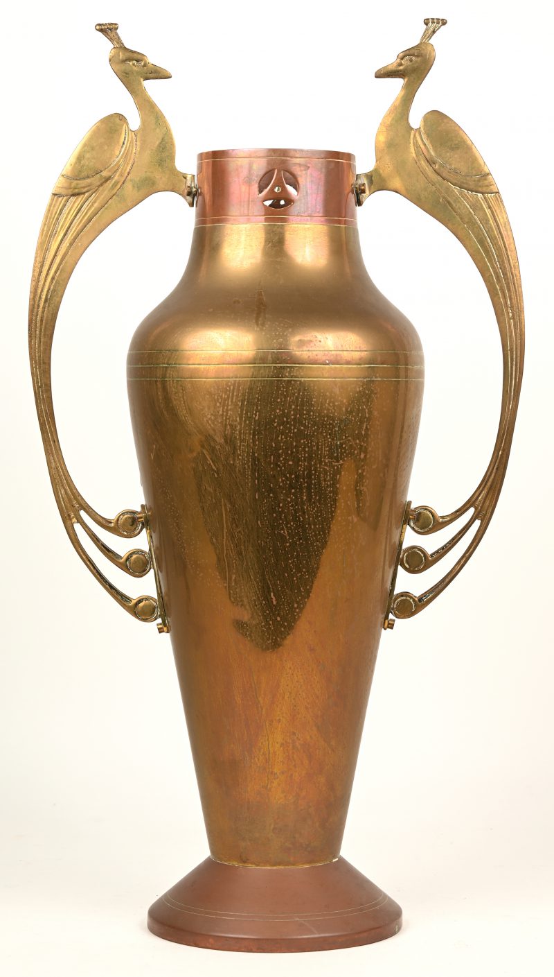 Een art nouveau vaas van koper en messing met oren in de vorm van pauwen.