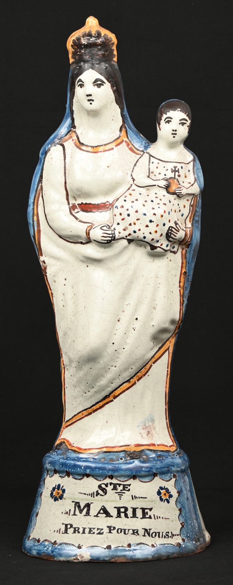 Een Madonna met kind van meerkleurig aardewerk van Quimper. Achteraan gedateerd 1842.