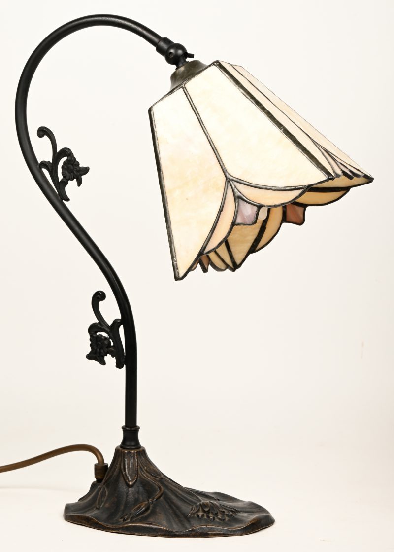 Een bronzen bureaulampje met kapje van glas in lood.