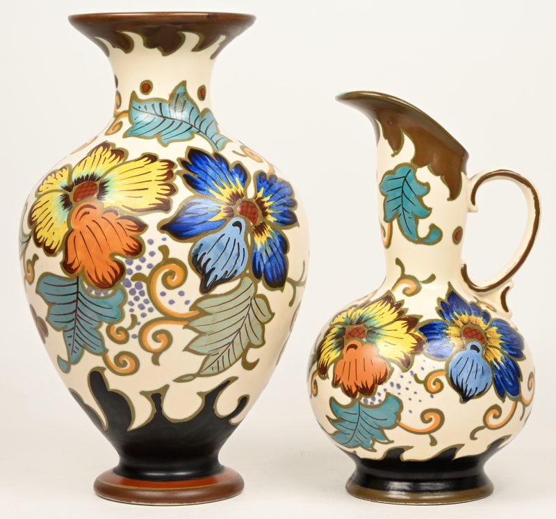 Een vaas en een schenkkan van meerkleurig Gouds plateel met decor ‘Gobana’. Onderaan gemerkt.