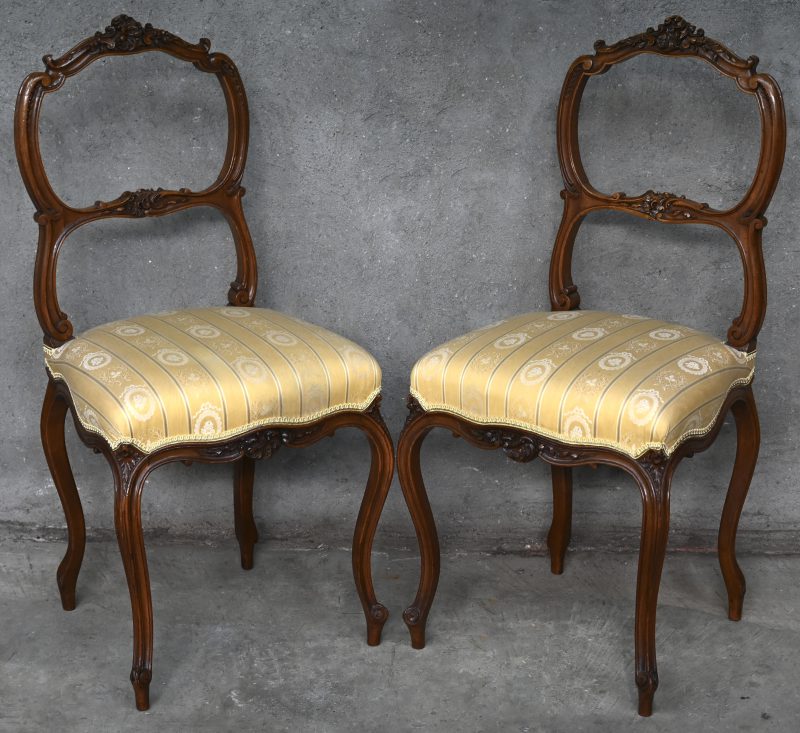 Een paar bijzetstoeltjes in Lodewijk XV-stijl met fijn uitgestoken versieringen.