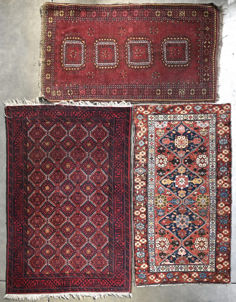 Een lot van drie verschillende handgeknoopte Oosterse wollen tapijtjes.