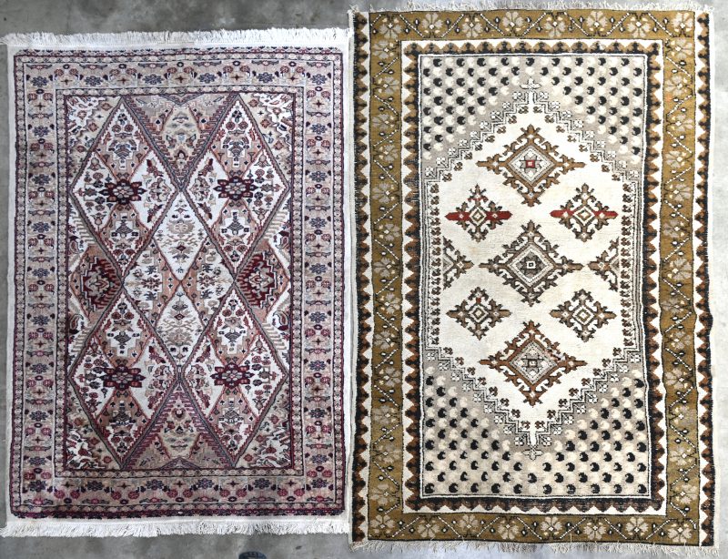 Twee verschillende handgeknoopte karpetjes, waarbij één van wol (gerepareerd) en één van wol en katoen.