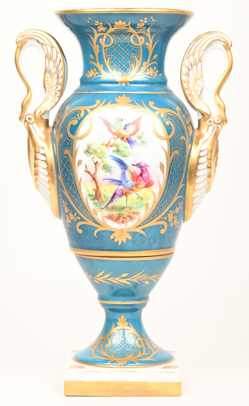 Een vaas op vierkant voetstuk van veelkleurig porselein met een decor van vogels en bloemen in uitsparingen, omlijst met goud en op lichtblauwe achtergrond. Onderaan gemerkt.