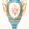 Een vaas op vierkant voetstuk van veelkleurig porselein met een decor van vogels en bloemen in uitsparingen, omlijst met goud en op lichtblauwe achtergrond. Onderaan gemerkt.