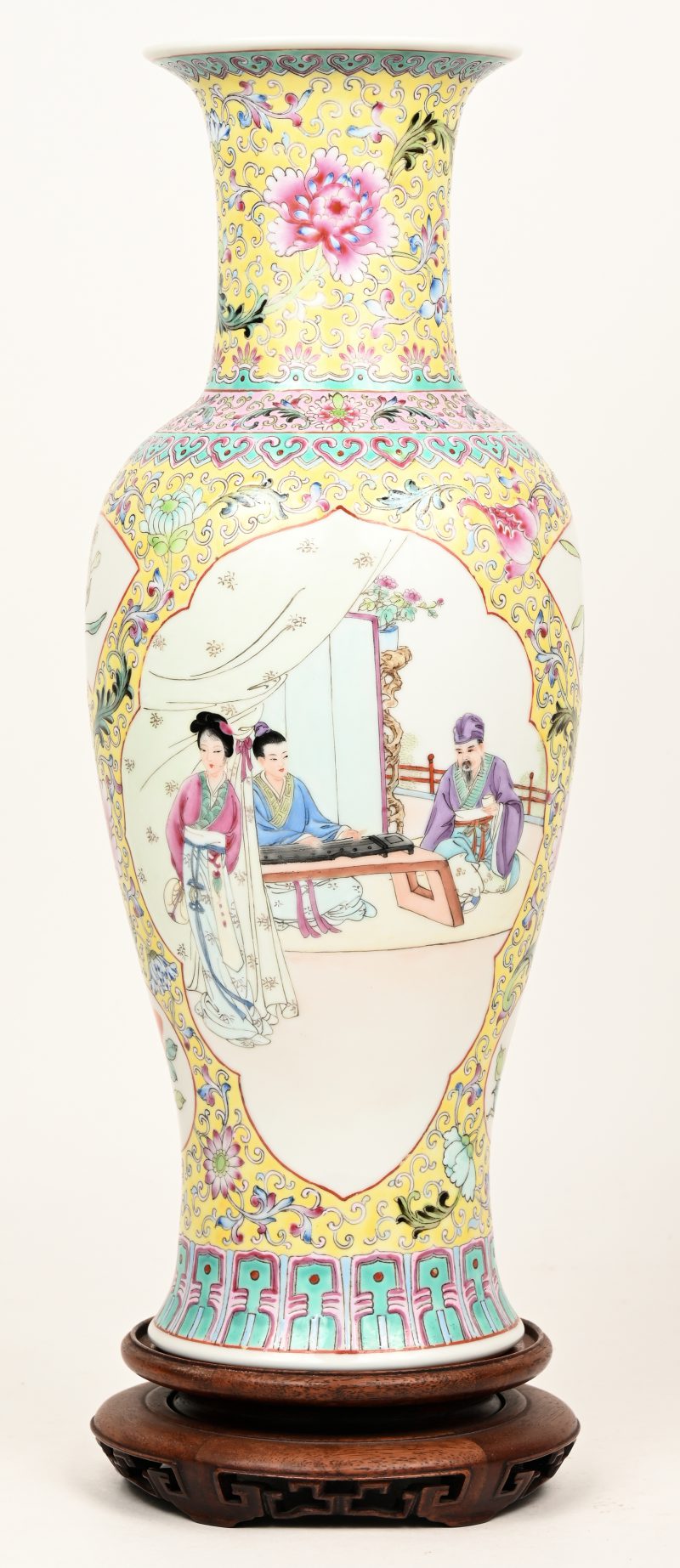 Een balustervaas van Chinees porselein met een famille jaune decor met personages in uitsparingen. Onderaan gemerkt “Qianlong Nian Zhi”. Met houten sokkeltje.