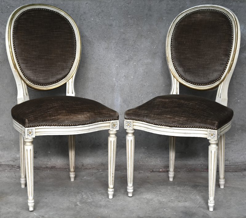 Een paar witgepatineerde stoelen in Lodewijk XVI-stijl, bekleed met grijs fluweel.
