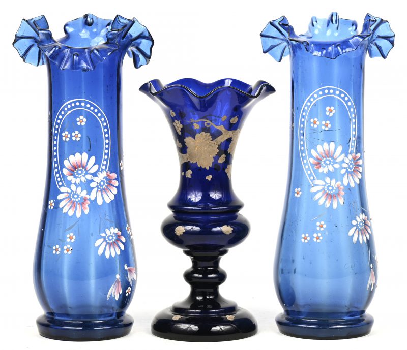 Een paar antiek blauw glazen vaasjes met handgeschilderd bloemendecor. We voegen er een derde blauw glazen vaasje met deels verguld bladerdecor aan toe.