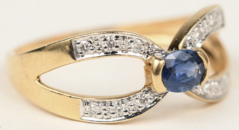Een 18 K geelgouden ring bezet met een centrale saffier van +- 0,25 ct. en kleine briljantjes met een gezamenlijk gewicht van +- 0,12 ct.