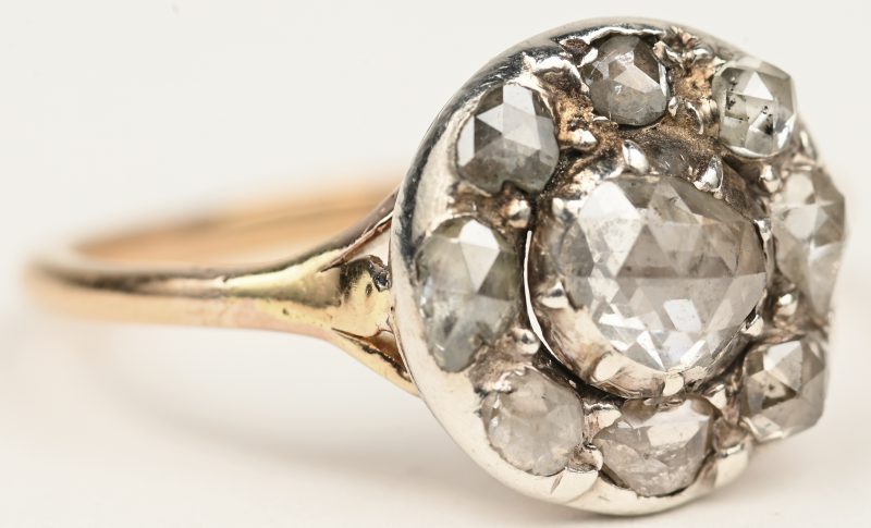 Een 18 K wit-en geelgouden ring bezet met drie diamanten oude slijp met een gezamenlijk gewicht van +- 1ct.