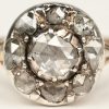 Een 18 K wit-en geelgouden ring bezet met drie diamanten oude slijp met een gezamenlijk gewicht van +- 1ct.