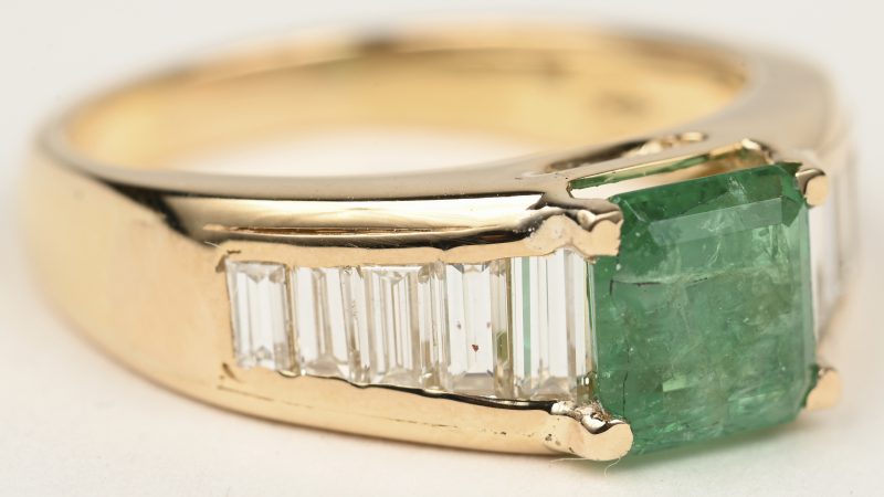 Een 18 K geelgouden ring bezet met diamant baguettes met een gezamenlijk gewicht van +- 0,90 ct. en een vierkante smaragd van +- 1,14 ct. Met ALGT certificaat.