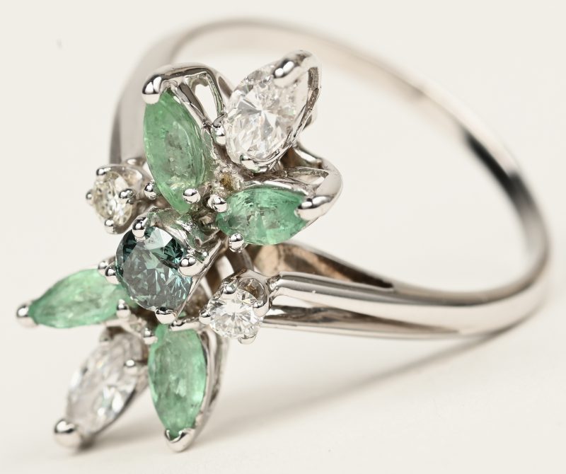 Een 18 K witgouden ring bezet met een centrale groene diamant van +- 0,17 ct. en twee diamanten in markies geslepen met een gezamenlijk gewicht van +- 0,36 ct. en vier smaragden in markies geslepen van +- 0,40 ct. Met ALGT certificaat.