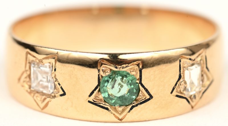 Een 18 K geelgouden ring bezet met diamanten baguettes met een gezamenlijk gewicht van +- 0,20 ct. en en smaragd van +- 0,15 ct.