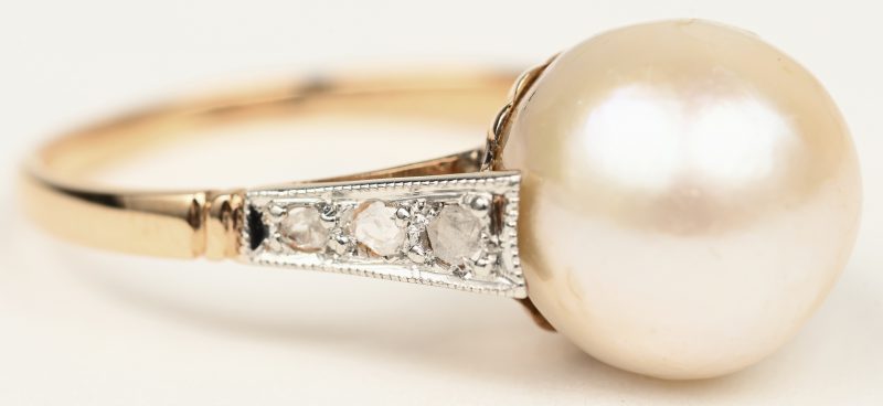 Een 18 K wit-en geelgouden ring bezet met diamanten oude slijp met een gezamenlijk gewicht van +- 0,14 ct. en een parel.