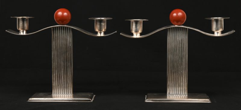 Twee vintage designkandelaars van zilver versierd met rode bolletjes.