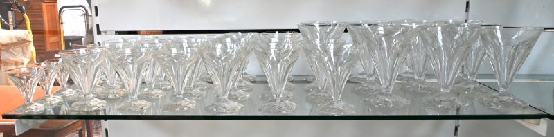Een kleurloos kristallen glazenservies, bestaande uit 11 waterglazen (één beschadigd), 11 rodewijnglazen (één beschadigd), 11 wittewijnglazen en 9 likeurglaasjes. Compleet voor twaalf personen.