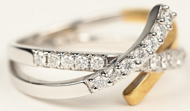 Een 18 K wit-en geelgouden ring bezet met briljanten met een gezamenlijk gewicht van +- 0,54 ct.