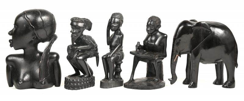 Een lot fijngesneden afrikaanse houten beeldjes bestaande uit onder anderen; een vrouwenbuste, een olifant en een djembéspeler.
