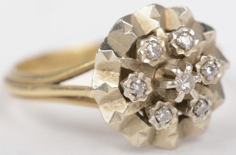 Een 18 K wit en geelgouden ring bezet met diamant oude slijp van +- 0,10 ct.