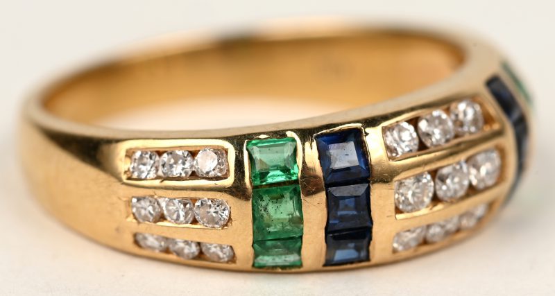 Een 18 K geelgouden ring bezet met diamanten en safier en smaragd baguettes met een gezamenlijk gewicht van +- 0,80 ct.