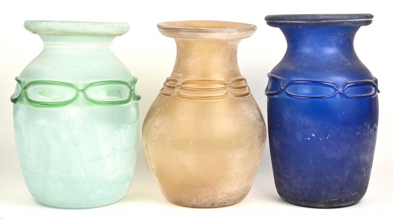 Een lot bestaande uit een blauwe, een groene en een amberkleurige ruw gemaakte handgeblazen glazen vaas.