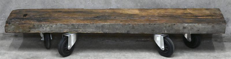 Een zware eikenhouten balk, afkomstig uit de Sint Sulpitiuskerk te Diest. Voor XVe eeuw. Op wielen.